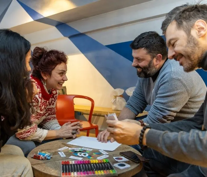 Colleghi Kid Pass al lavoro attorno a un tavolo con fogli e pennarelli