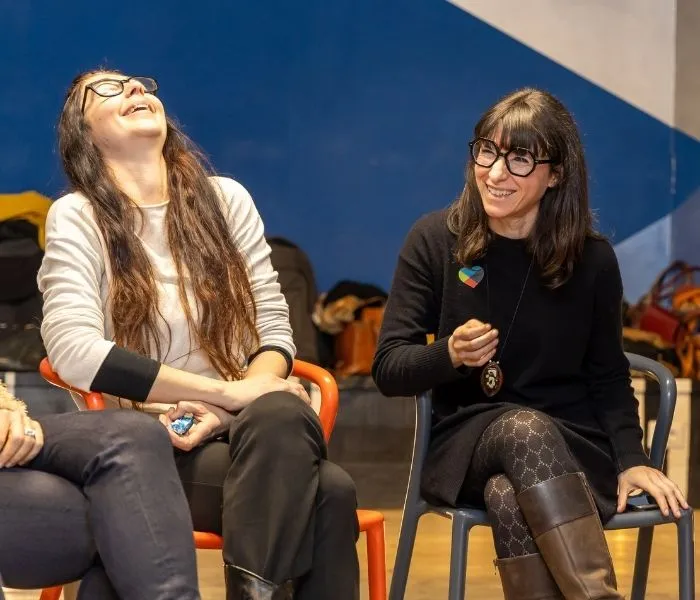 Due collaboratrici Kid Pass ridono durante un incontro